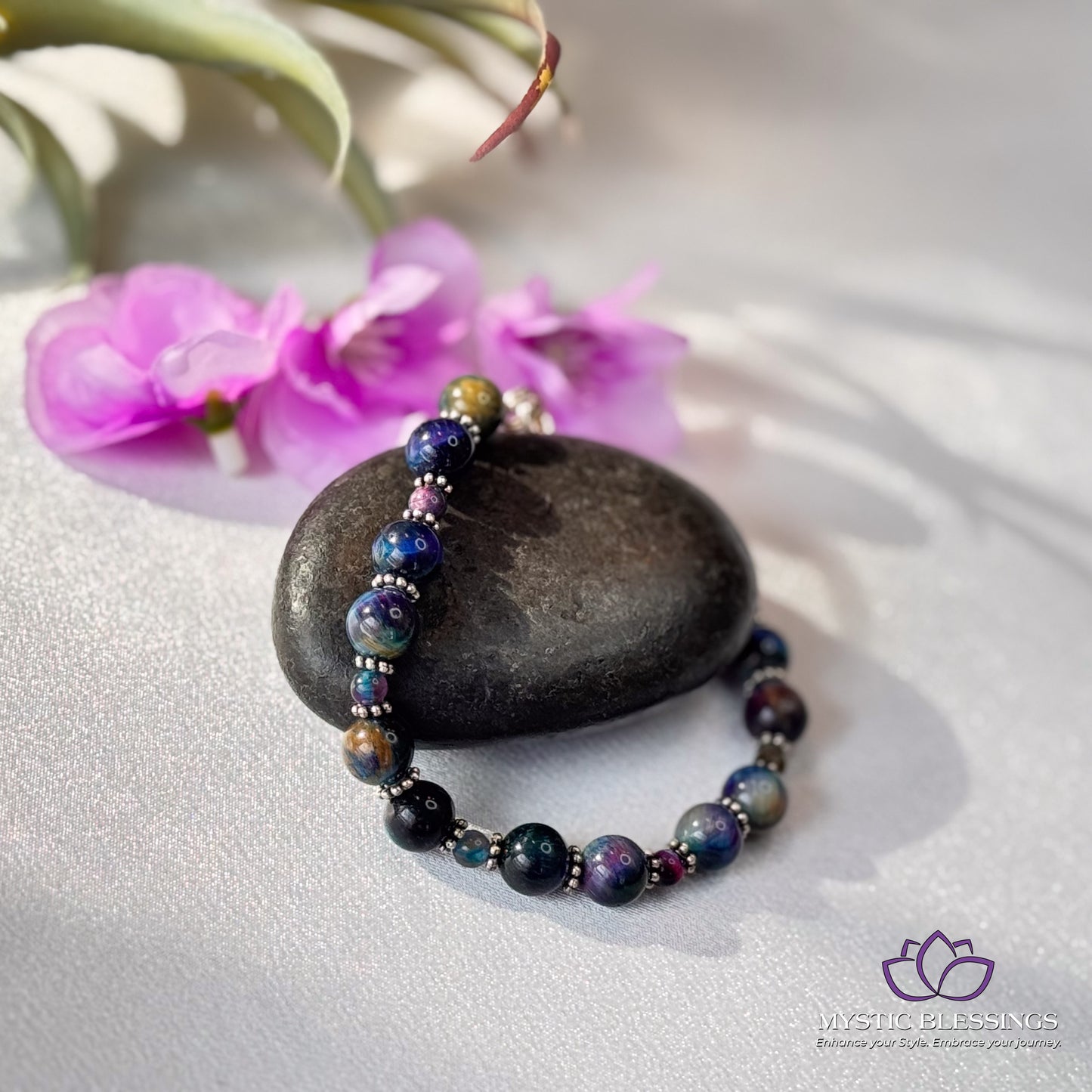 a stone with a beaded bracelet sitting on top of it