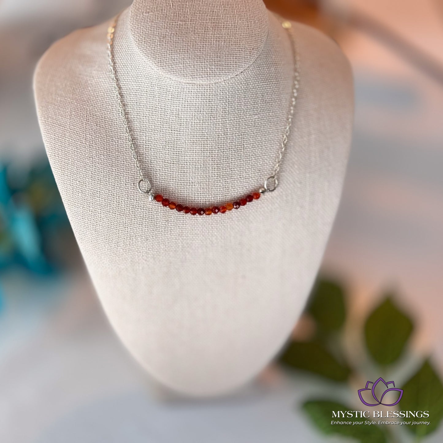 a white mannequin with a red beaded necklace on it