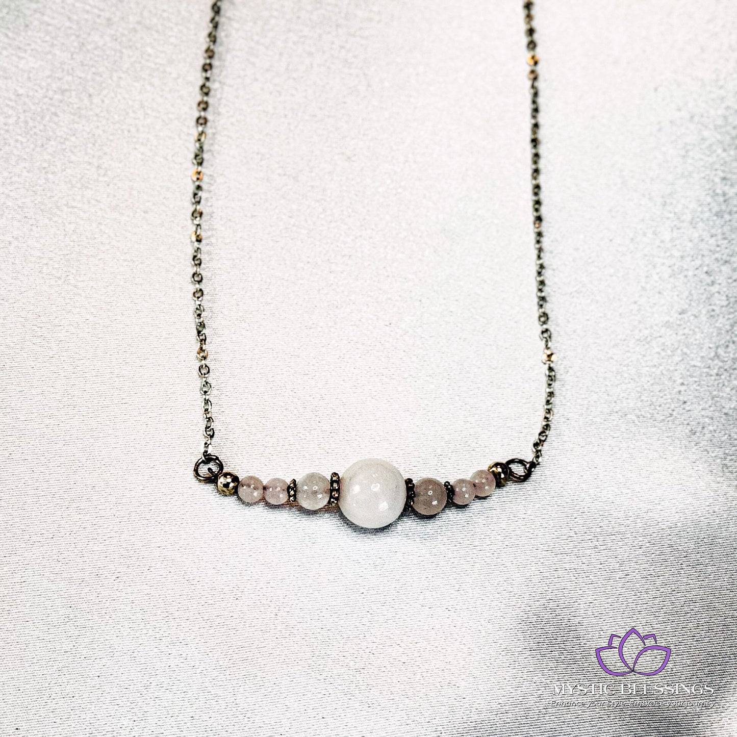 a necklace with a white bead and a black bead