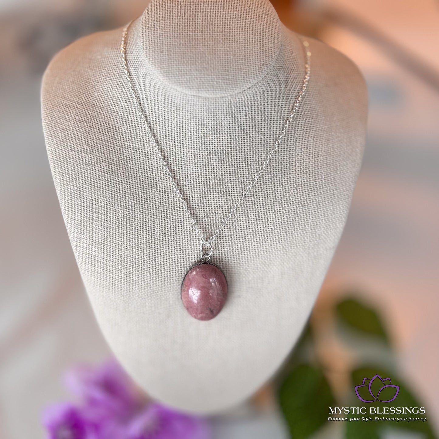 a white mannequin with a pink necklace on it