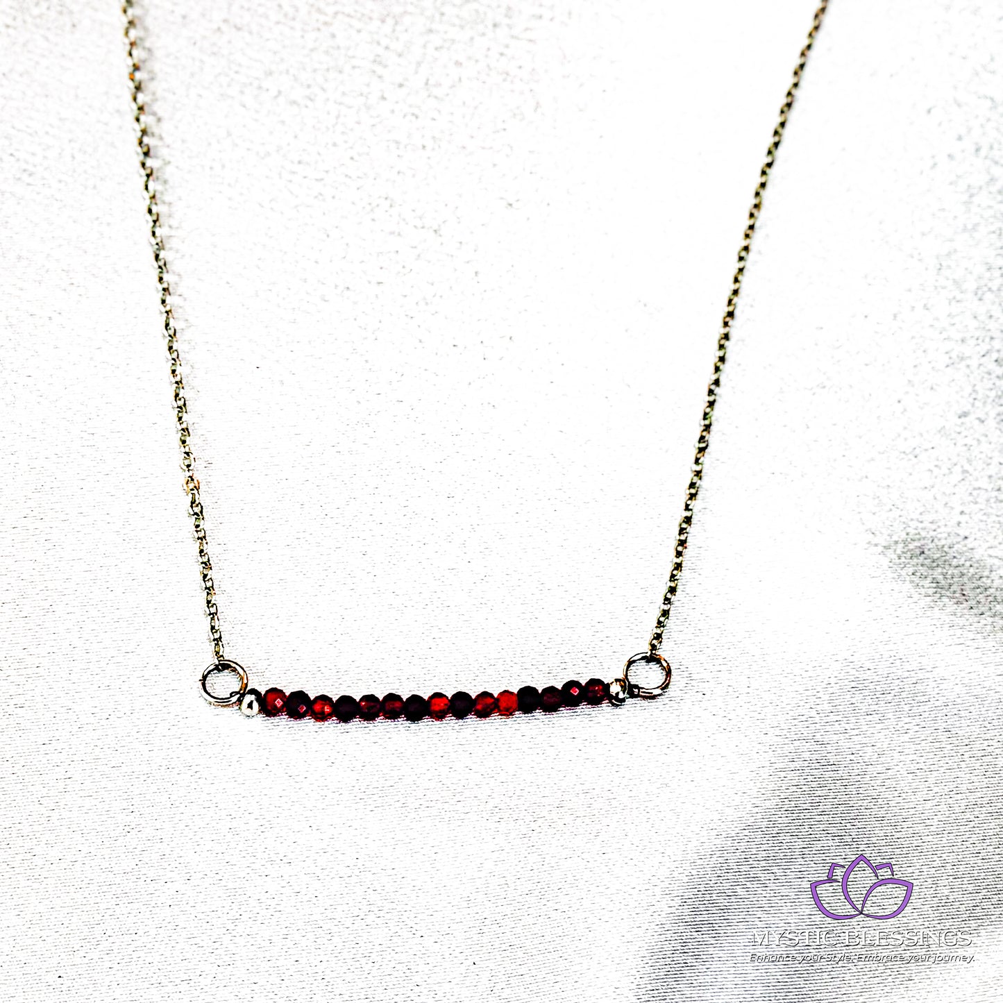 a necklace with a red bead hanging from it