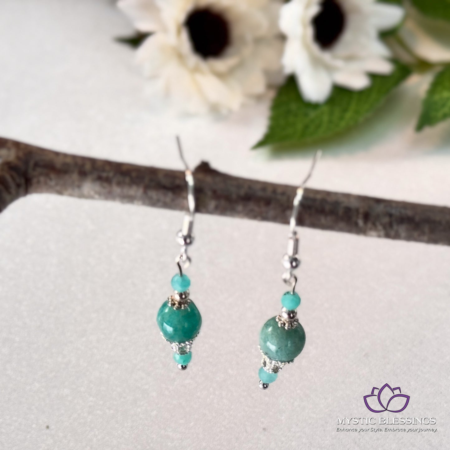 a close up of a pair of earrings on a branch