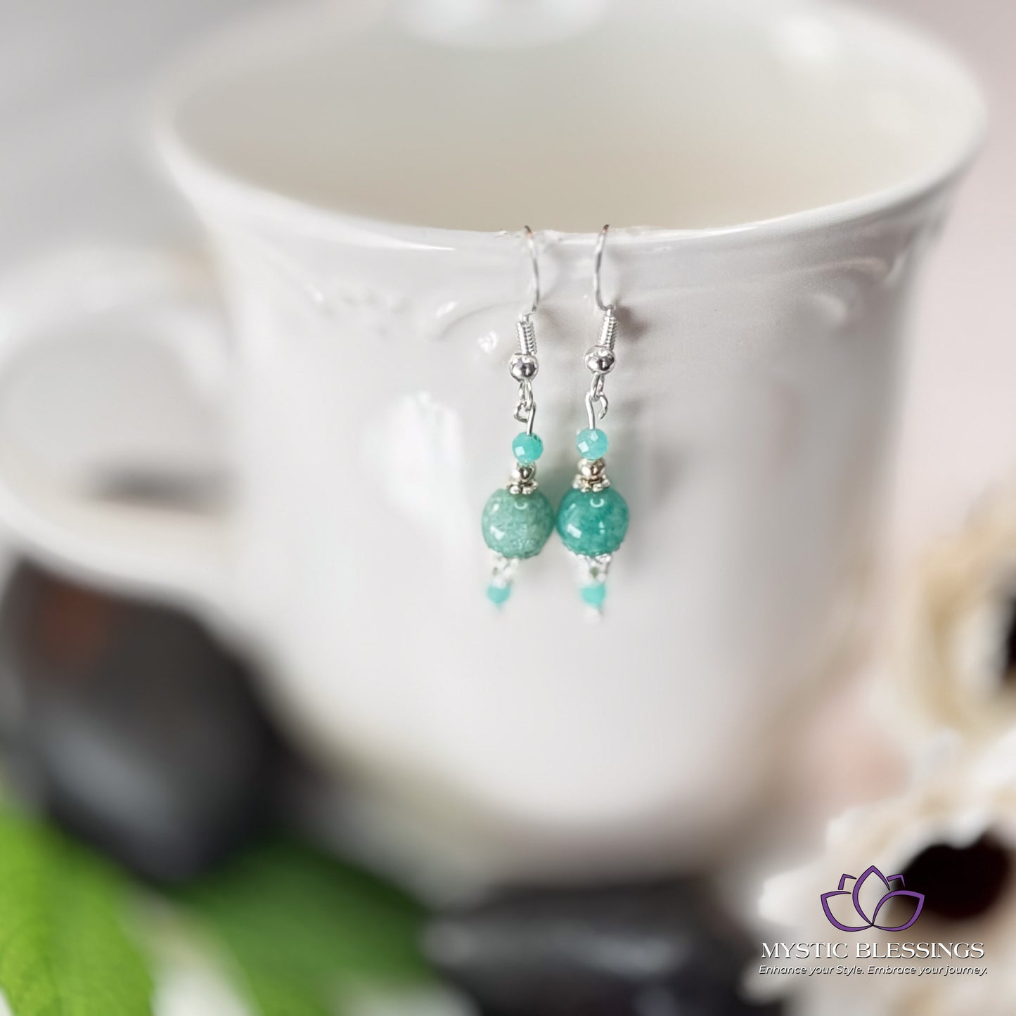 a close up of a cup with a pair of earrings on it