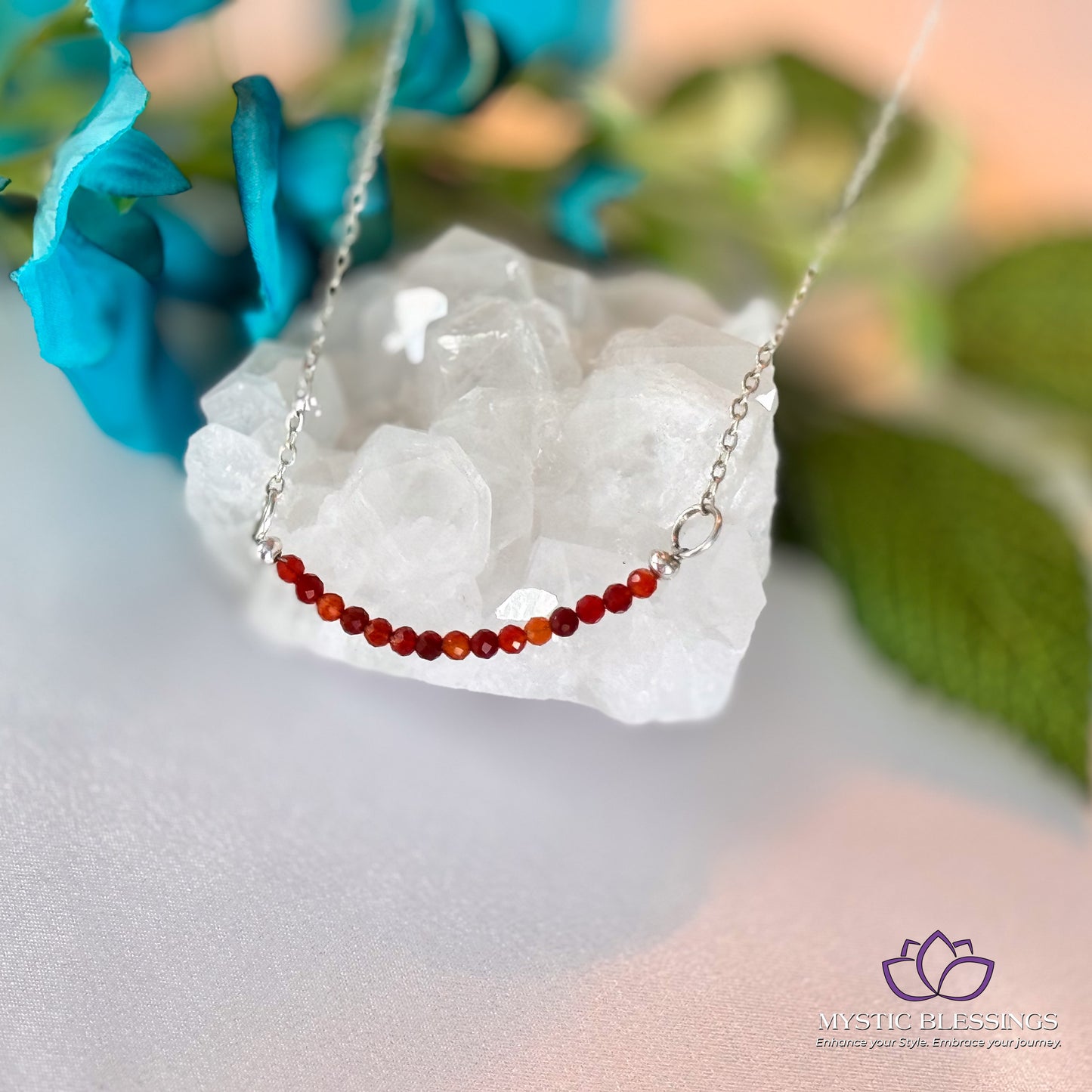 a red beaded necklace sitting on top of a rock