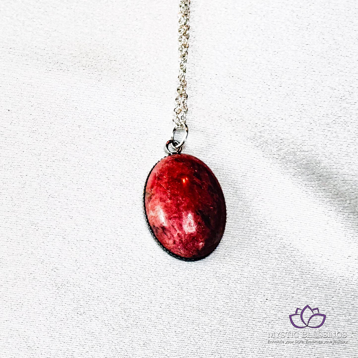 a red apple is hanging from a silver chain