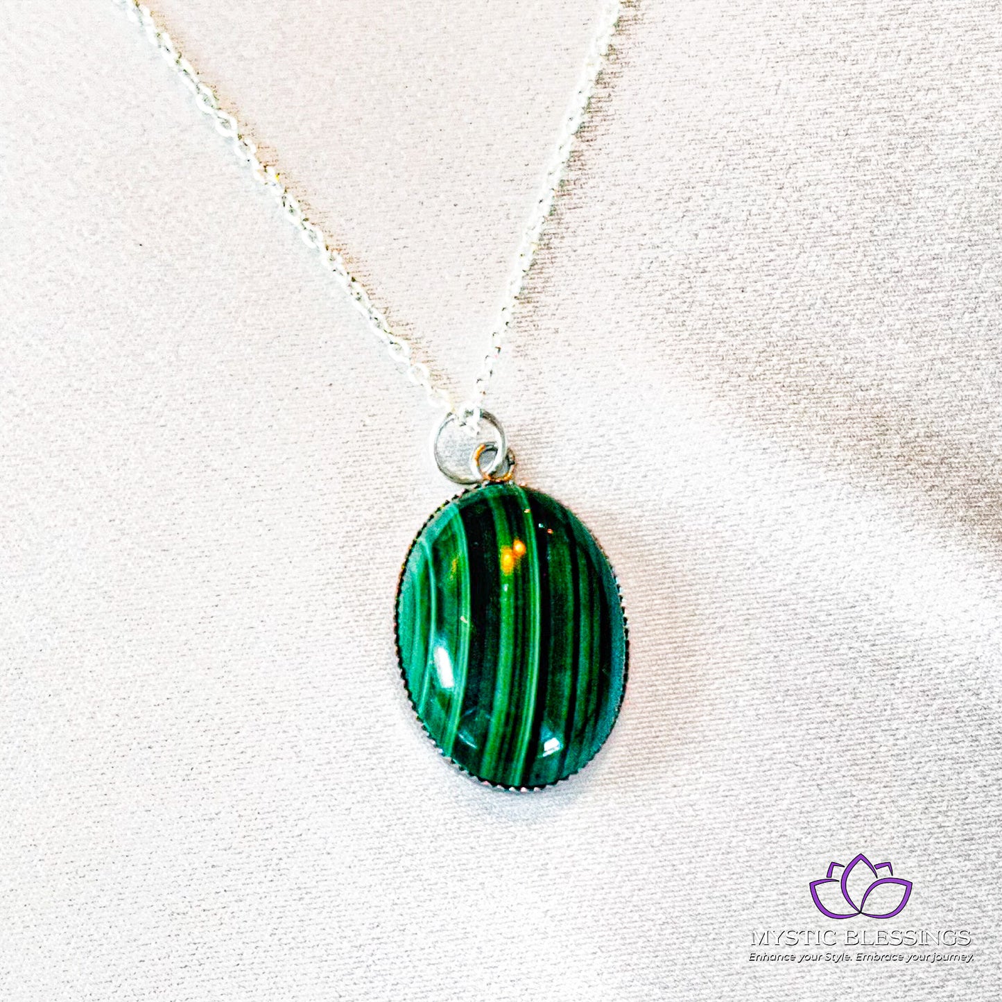 a necklace with a green glass ball on a silver chain