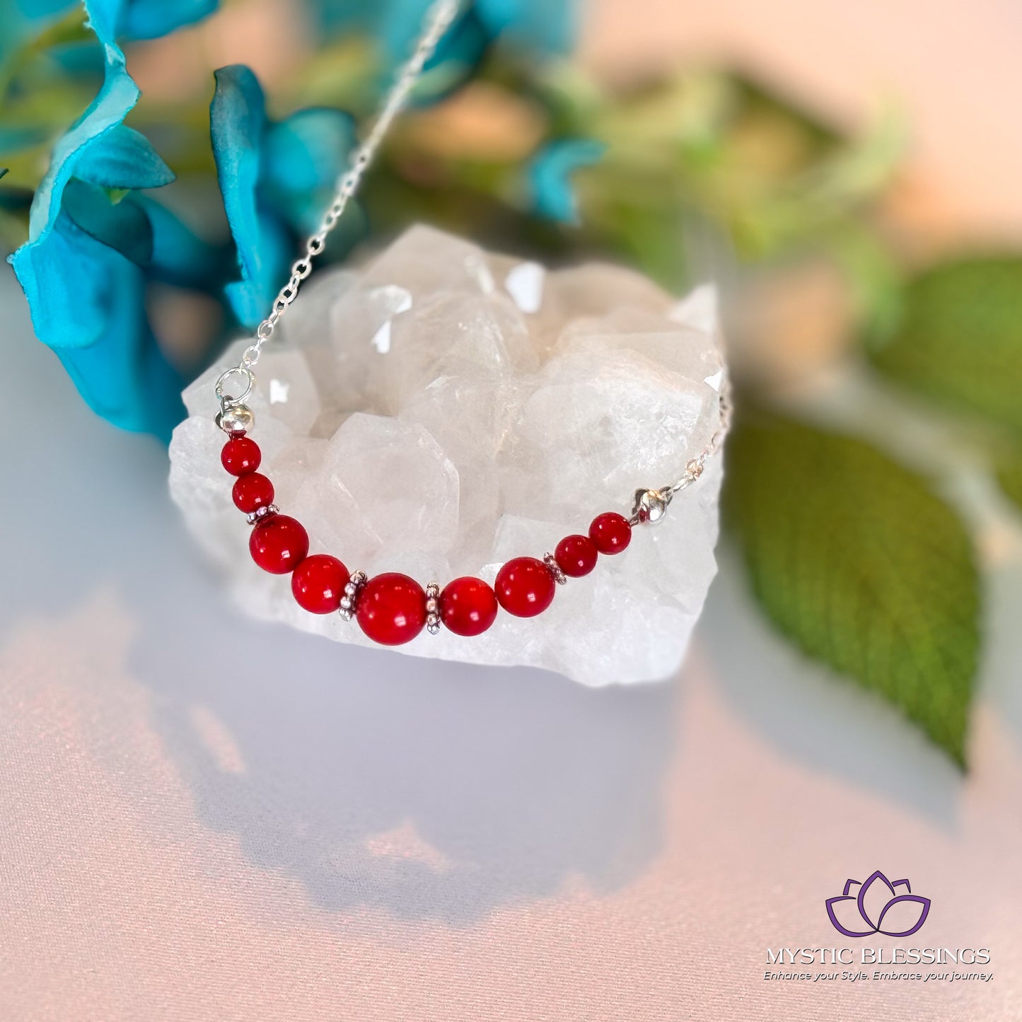 a red beaded necklace sitting on top of a rock
