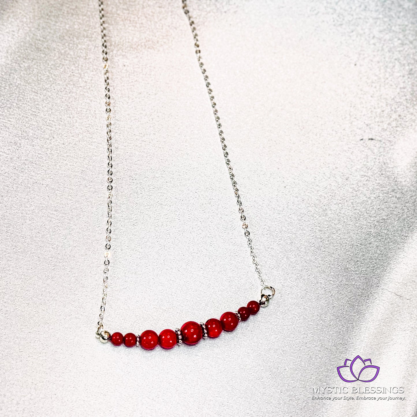 a red beaded necklace on a silver chain
