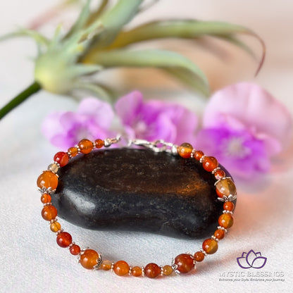 a close up of a beaded bracelet on a rock