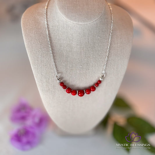 a white mannequin with a red beaded necklace on it