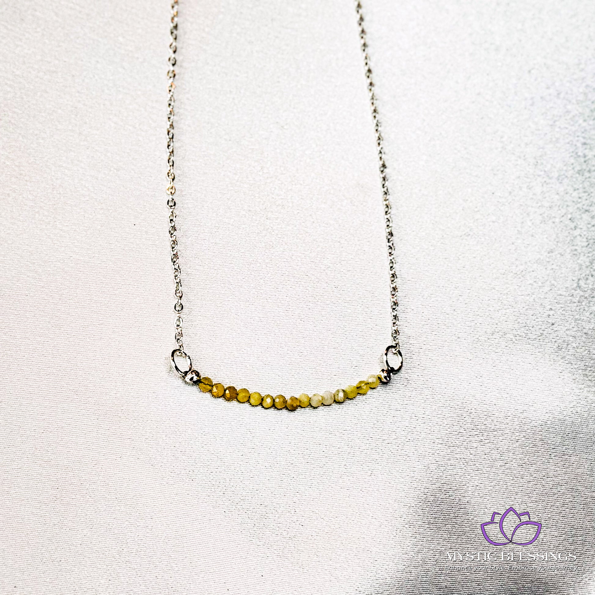 a silver chain with a yellow bead on it