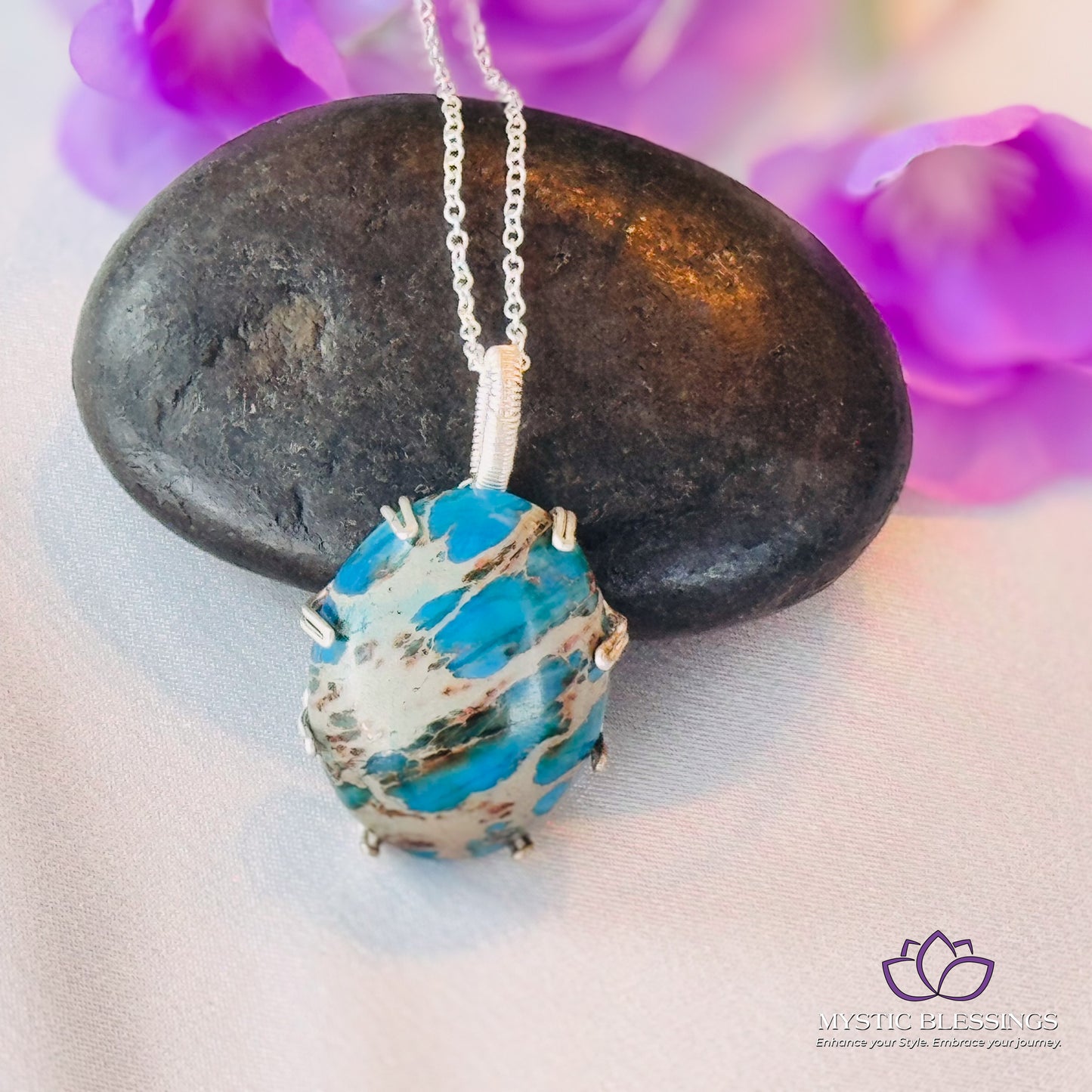 a blue and white necklace sitting on top of a rock