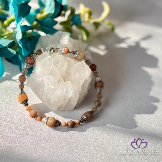 a beaded bracelet sitting on top of a table next to flowers