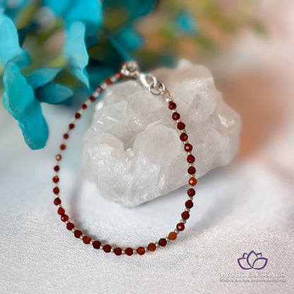 a red beaded necklace sitting on top of a rock