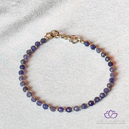 a purple beaded bracelet with a gold clasp