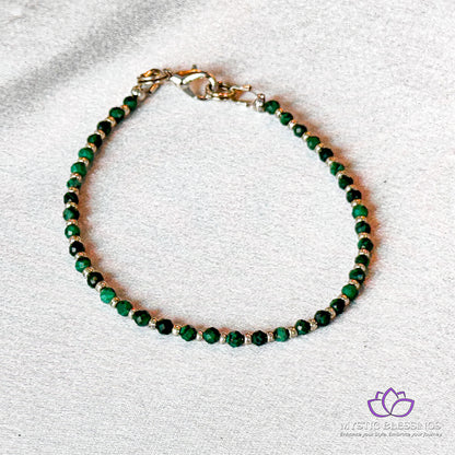 a green beaded bracelet on a white surface