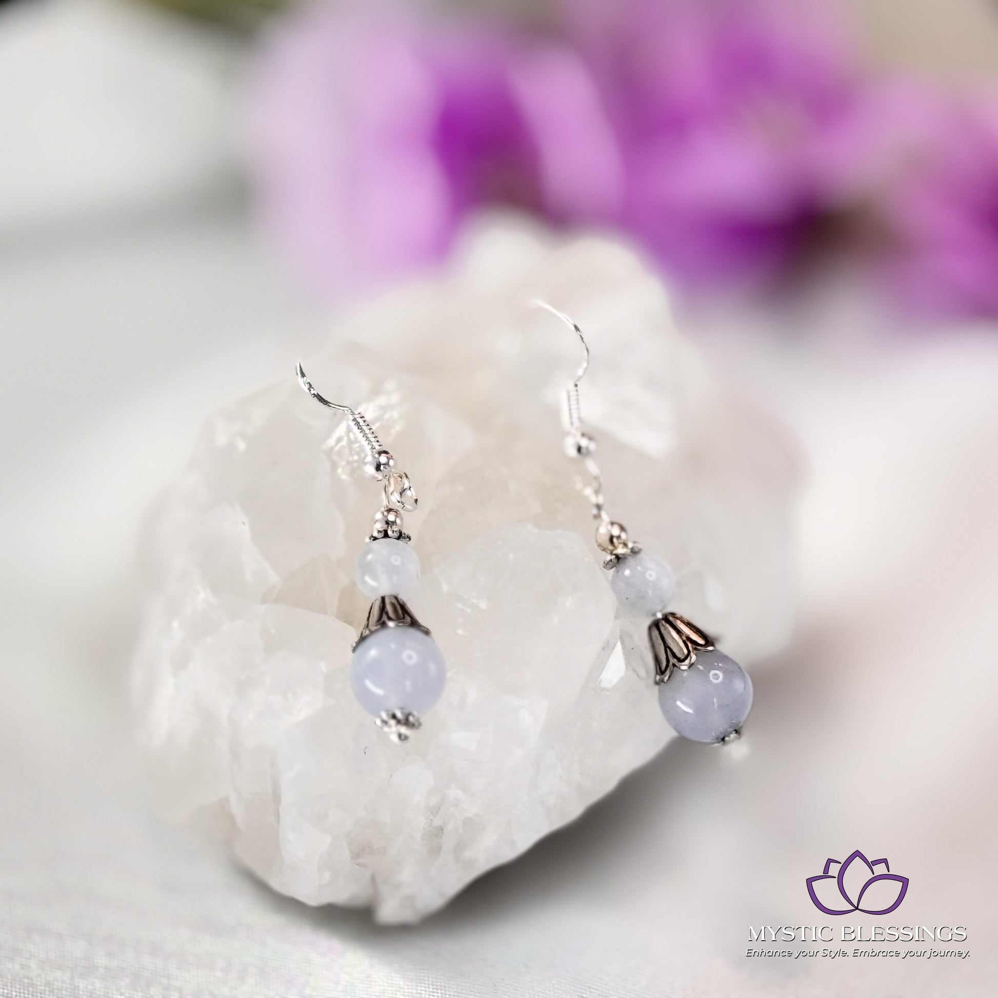 a pair of earrings sitting on top of a rock