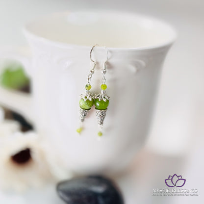 a close up of a cup with a pair of earrings on it