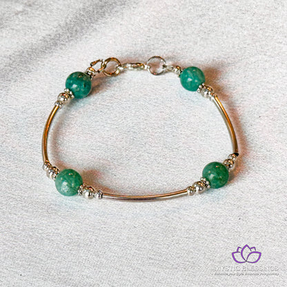 a bracelet with green beads on a white surface