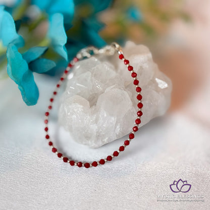 a red beaded necklace sitting on top of a rock