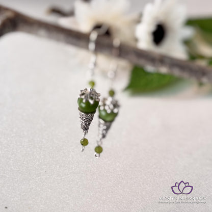 a close up of a pair of earrings on a branch