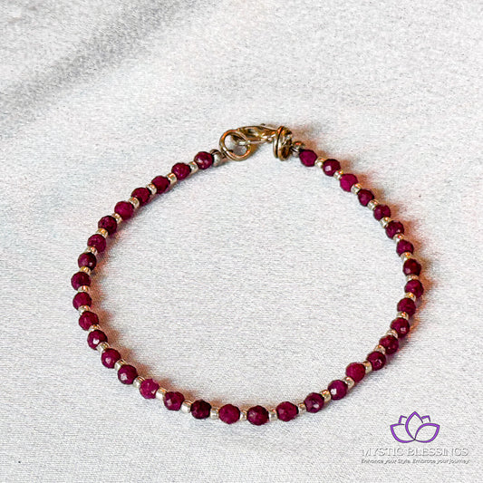 a red beaded bracelet with a gold clasp