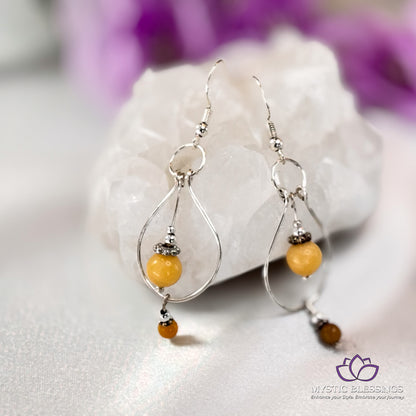 a pair of silver hoop earrings with yellow beads