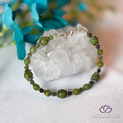 a green beaded bracelet sitting on top of a table