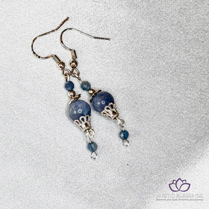 a pair of earrings with blue beads hanging from them