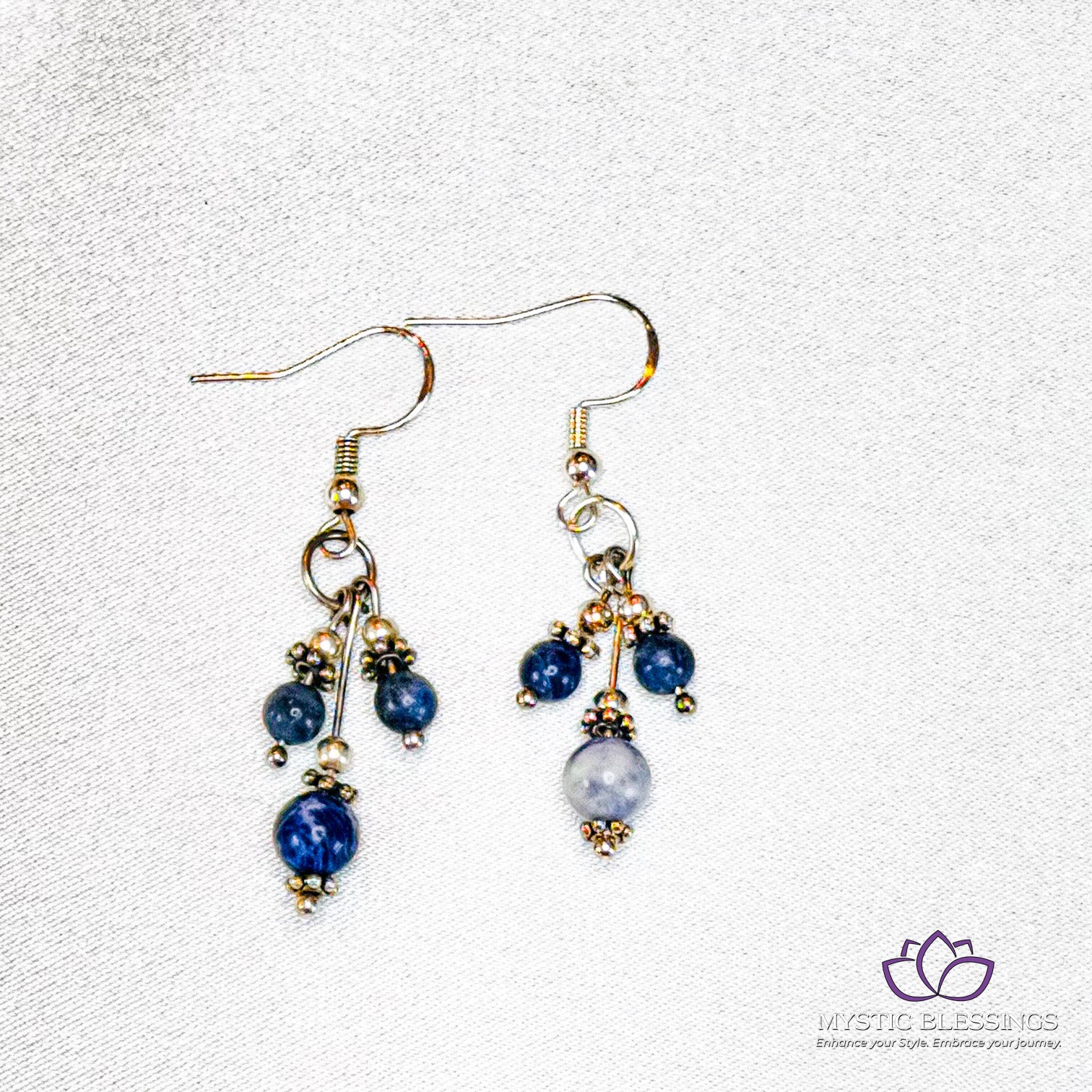 a pair of blue and white earrings on a white background