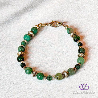 a bracelet with green beads and gold accents